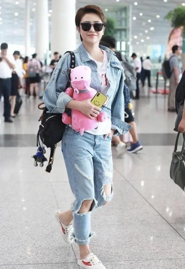 马丽和老公走机场，染黄毛踩凉拖变小太妹，小11岁老公身材壮硕