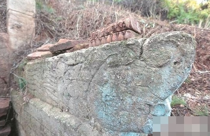 古墓“扶手”有龙头雕刻。